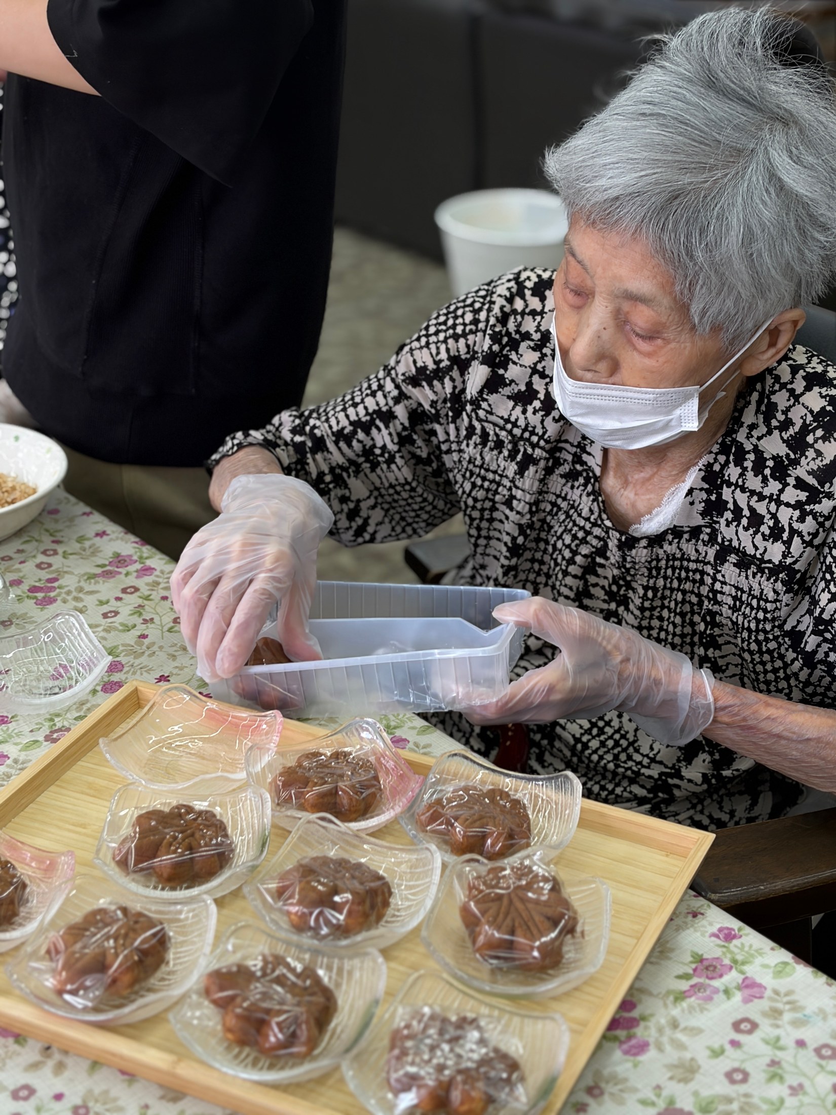 利用者さんと一緒にもみじ饅頭を一つずつ準備している様子
