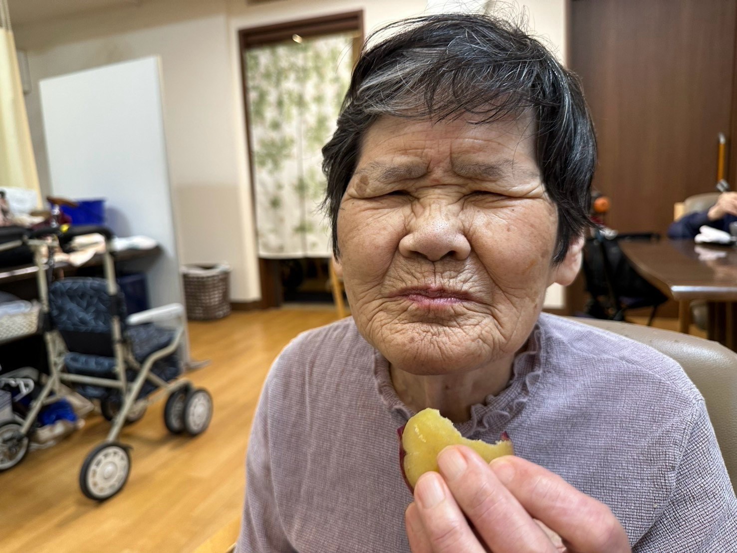 さつまいもを手に、目を閉じて味わっている利用者さん