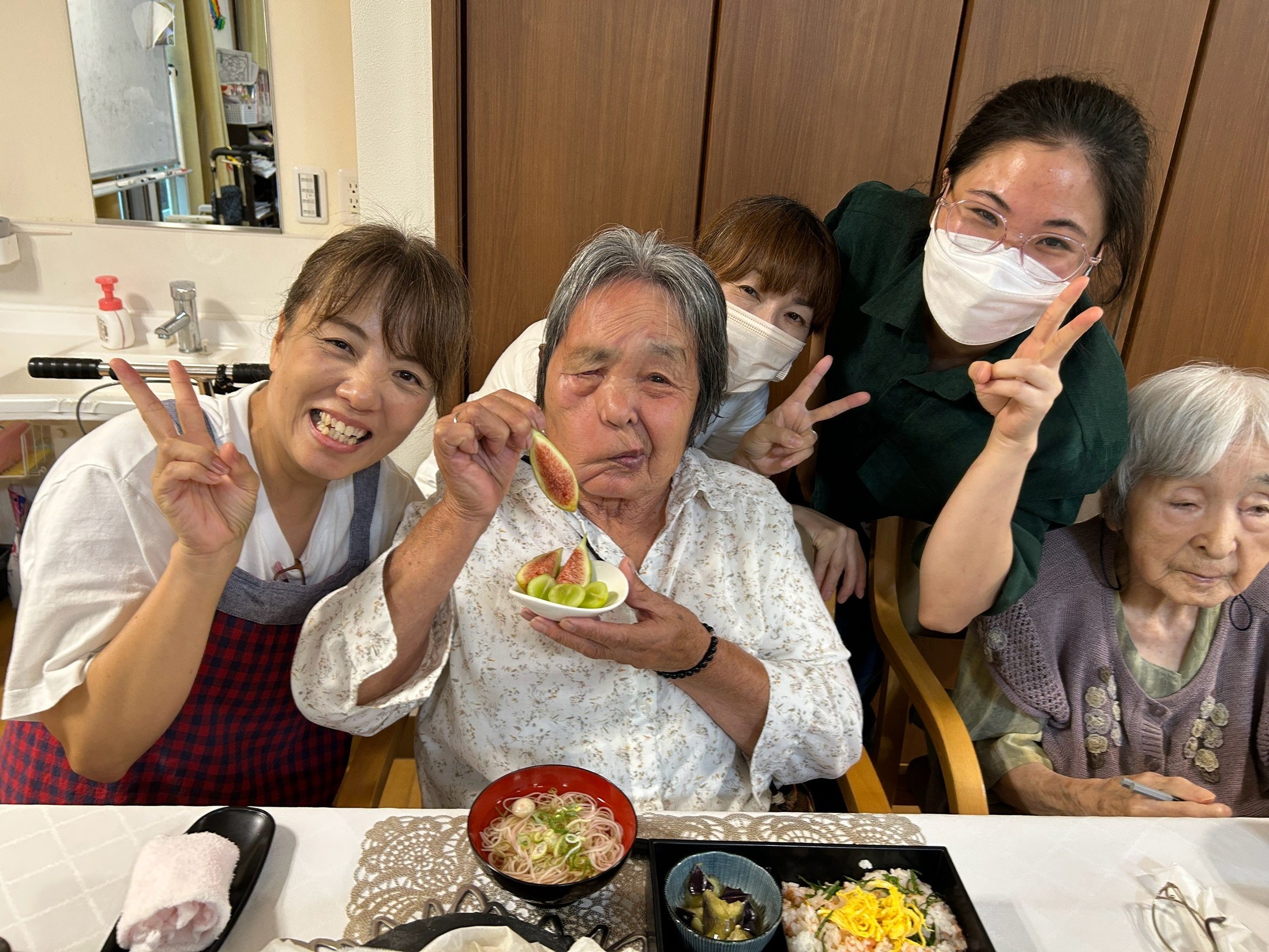 いちじくとぶどうを手にした利用者さんと職員