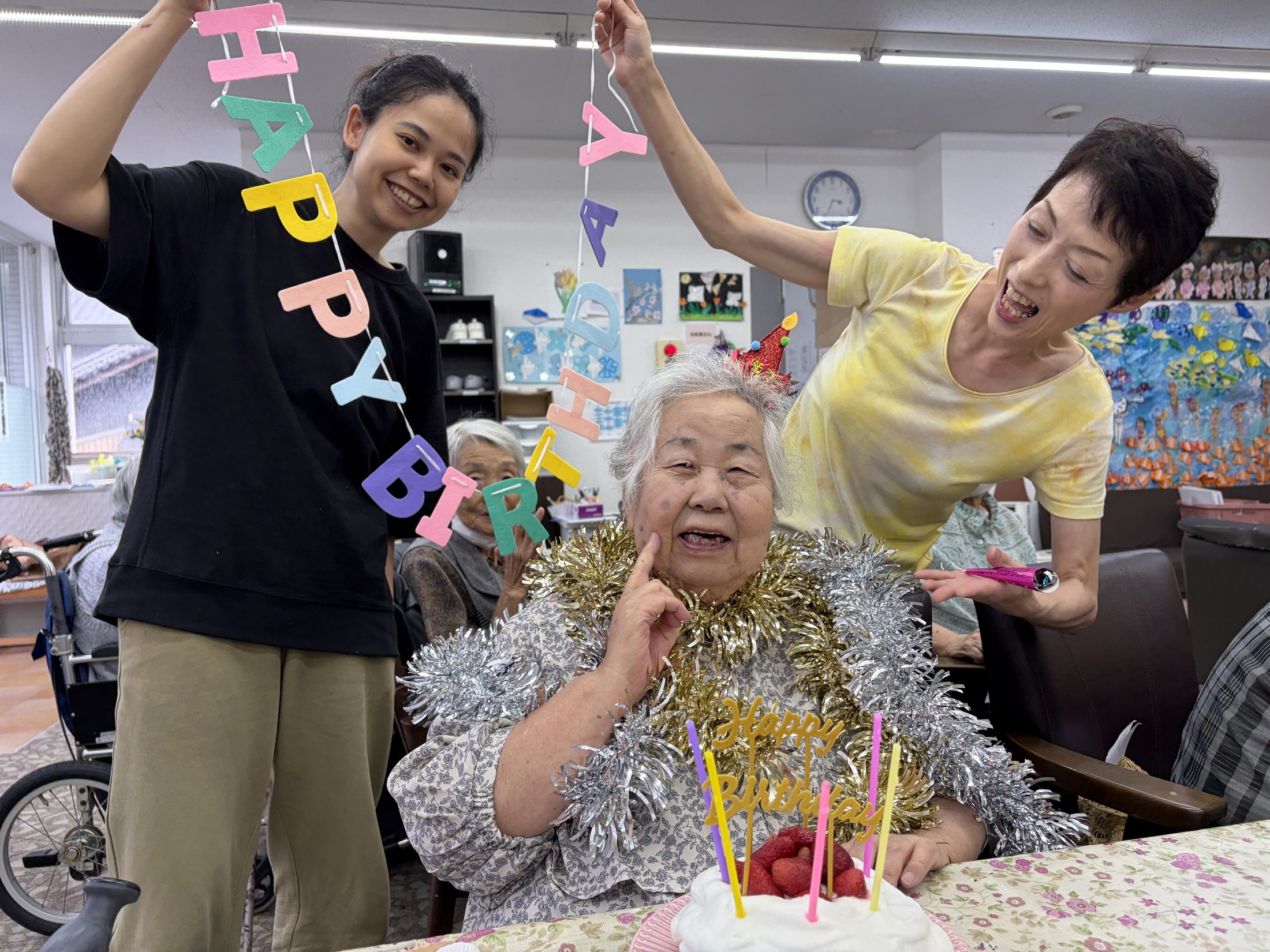 いちごのケーキを前に白山の利用者さんと職員がお祝いする様子