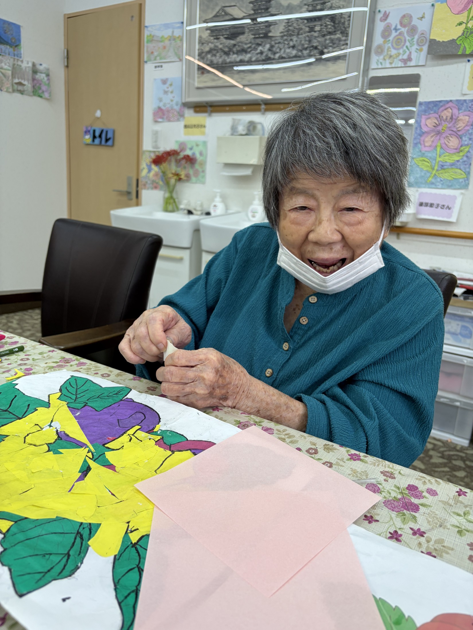 色紙を手に花の貼り絵を進める利用者さん